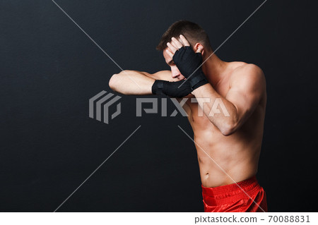 Sportsman muay thai man boxer stance ad elbow punch at black background Sportsman muay thai man boxer stance ad elbow punch at black background 70088831