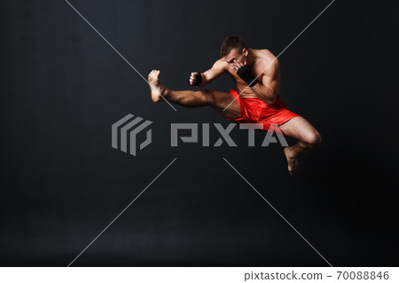 Sportsman muay thai man boxer stance at black background Sportsman muay thai man boxer stance at black background 70088846