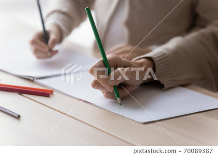 Close up mature grandmother and little girl drawing together Close up mature grandmother and little girl drawing together 70089387