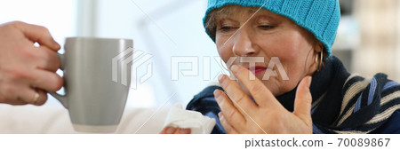 Lady sitting on sofa indoors Lady sitting on sofa indoors 70089867