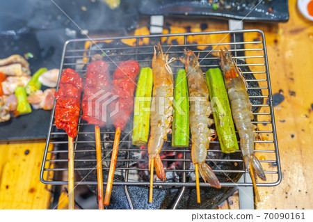 Barbecue shrimp skewers and marinated meat stick grilling on stove 70090161