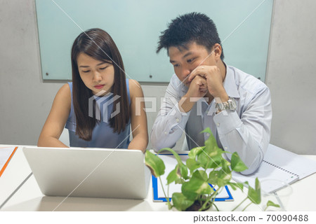 Asian business people working together on laptop 70090488