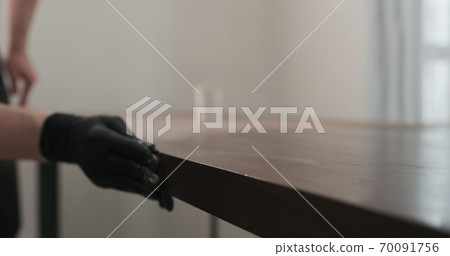 man hand applying oil finish to toned walnut table with cloth man hand applying oil finish to toned walnut table with cloth 70091756