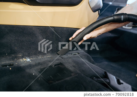 Worker hand with vacuum cleaner cleans car trim Worker hand with vacuum cleaner cleans car trim 70092818