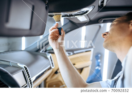 Worker wipes car interior, detailing 70092832