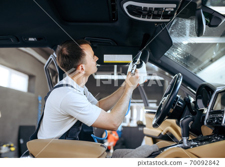 Worker watering car interior, detailing 70092842