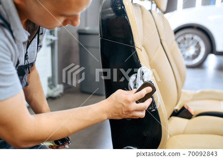 Worker wipes car seat, dry cleaning and detailing 70092843