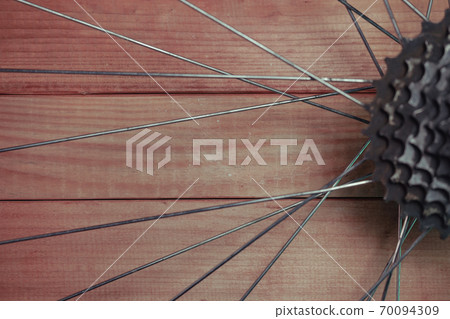 Close up bicycle parts on a red wooden background. 70094309