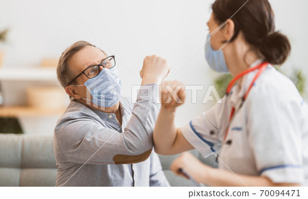 Doctor and senior man wearing facemasks 70094471