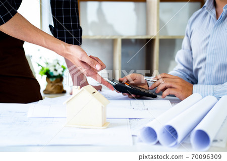 Engineers or architects are meeting a team to design the architectural structure in the design with blueprints and model buildings in working site, Technological structure and construction Concept. Engineers or architects are meeting a team to design the architectural structure in the design with blueprints and model buildings in working site, Technological structure and construction Concept. 70096309