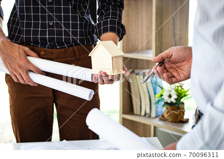 Engineers or architects are meeting a team to design the architectural structure in the design with blueprints and model buildings in working site, Technological structure and construction Concept. Engineers or architects are meeting a team to design the architectural structure in the design with blueprints and model buildings in working site, Technological structure and construction Concept. 70096311