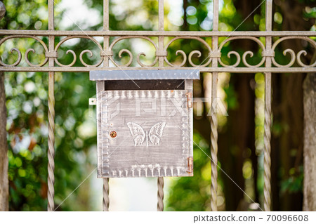 Close-up of a metal mailbox with a butterfly pattern on the gate, shallow depth of field. Close-up of a metal mailbox with a butterfly pattern on the gate, shallow depth of field. 70096608