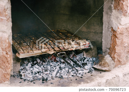 Lamb ribs are fried on coals on the grill. 70096723