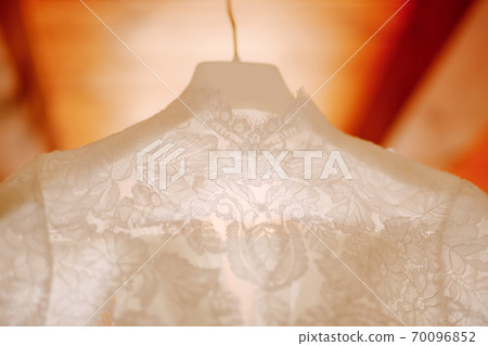 Close-up of the collar of a white dress for a wedding ceremony. Close-up of the collar of a white dress for a wedding ceremony. 70096852