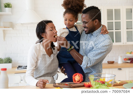 Positive mixed race family entertaining, enjoying cooking together. Positive mixed race family entertaining, enjoying cooking together. 70097084