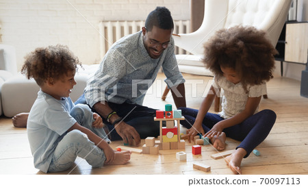 Smiling young african american father playing with children. Smiling young african american father playing with children. 70097113