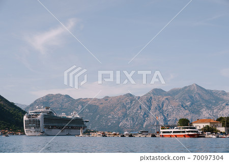 Liner in the Gulf of Kotor in Montenegro, against the backdrop of mountains and blue sky with clouds. Liner in the Gulf of Kotor in Montenegro, against the backdrop of mountains and blue sky with clouds. 70097304