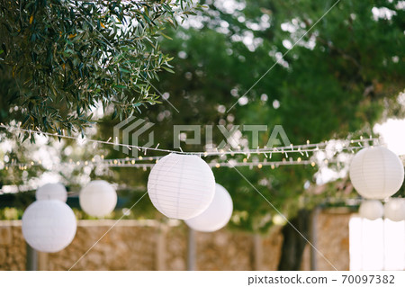 Paper lanterns. A garland of paper balls. Paper lanterns. A garland of paper balls. 70097382