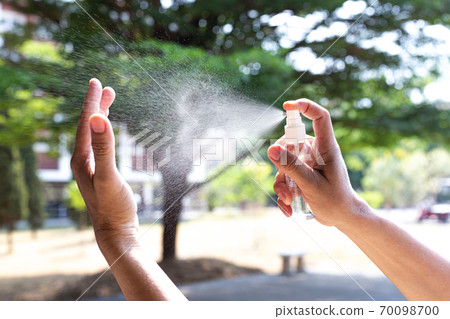 Man uses a spray of alcohol to get rid of bacteria and viruses, Inhibition and prevention of Covid-19 virus, protect virus concept. 70098700