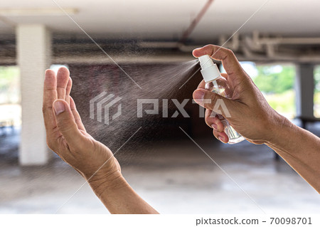 Man uses a spray of alcohol to get rid of bacteria and viruses, Inhibition and prevention of Covid-19 virus, protect virus concept. 70098701