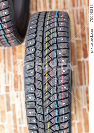 New, black winter car tires with spikes.  70098818