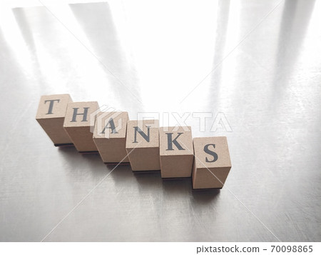 Dice letters lined up with THANKS in bright light 70098865