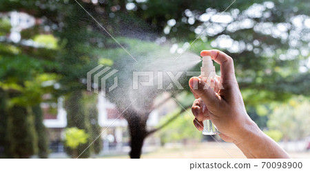 Man uses a spray of alcohol to get rid of bacteria and viruses, Inhibition and prevention of Covid-19 virus, protect virus concept. 70098900