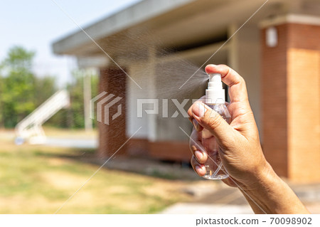 Man uses a spray of alcohol to get rid of bacteria and viruses, Inhibition and prevention of Covid-19 virus, protect virus concept. 70098902