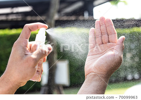 Man uses a spray of alcohol to get rid of bacteria and viruses, Inhibition and prevention of Covid-19 virus infection using 70 percent alcohol, protect virus concept. Man uses a spray of alcohol to get rid of bacteria and viruses, Inhibition and prevention of Covid-19 virus infection using 70 percent alcohol, protect virus concept. 70099963
