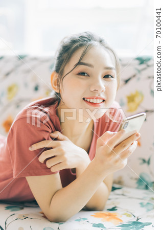 Woman lying on sofa 70100441