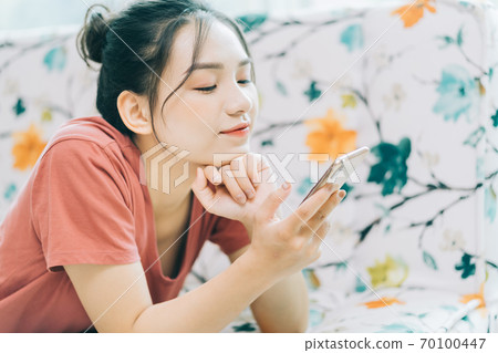 Woman lying on sofa 70100447