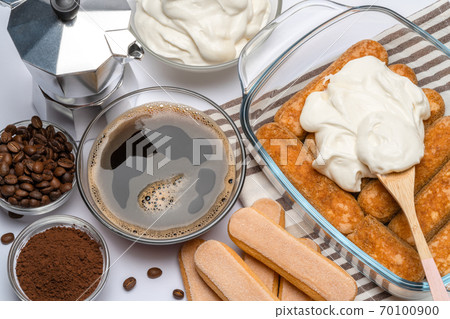tiramisu dessert cooking - Traditional Italian Savoiardi ladyfingers Biscuits and cream in glass baking dish isolated on white tiramisu dessert cooking - Traditional Italian Savoiardi ladyfingers Biscuits and cream in glass baking dish isolated on white 70100900