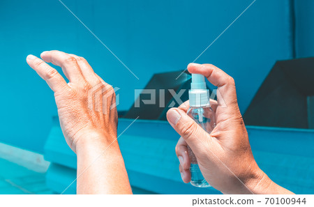 Man uses a spray of alcohol to get rid of bacteria and viruses, Inhibition and prevention of Covid-19 virus, protect virus concept. 70100944