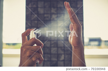 Man uses a spray of alcohol to get rid of bacteria and viruses, Inhibition and prevention of Covid-19 virus, protect virus concept. 70100948