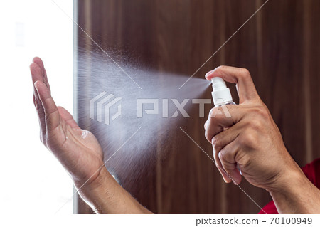 Man uses a spray of alcohol to get rid of bacteria and viruses, Inhibition and prevention of Covid-19 virus, protect virus concept. 70100949