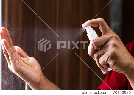 Man uses a spray of alcohol to get rid of bacteria and viruses, Inhibition and prevention of Covid-19 virus, protect virus concept. 70100950