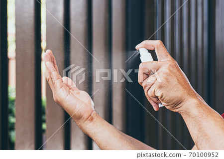 Man uses a spray of alcohol to get rid of bacteria and viruses, Inhibition and prevention of Covid-19 virus, protect virus concept. 70100952