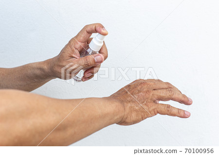 Man uses a spray of alcohol to get rid of bacteria and viruses, Inhibition and prevention of Covid-19 virus, protect virus concept. Man uses a spray of alcohol to get rid of bacteria and viruses, Inhibition and prevention of Covid-19 virus, protect virus concept. 70100956