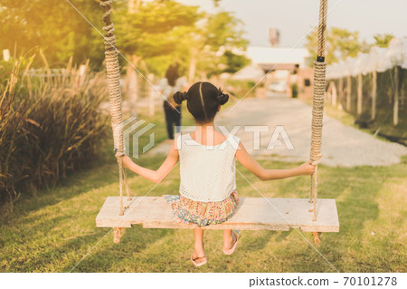 Back view of young girl sit on swings for wait her mom in the organic grapes farm. 70101278
