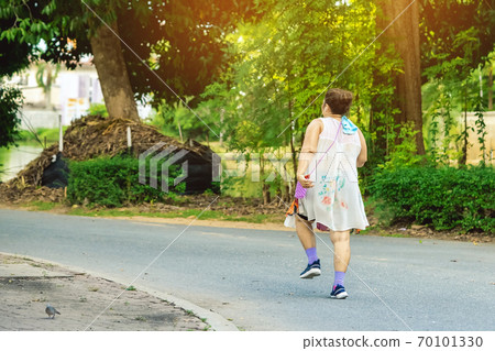 Back view of a Asian elderly woman wears earphone to listening song walking and jogging for good health in public park.Senior jogger in nature. Older female enjoying Peaceful nature.Healthcare concept Back view of a Asian elderly woman wears earphone to listening song walking and jogging for good health in public park.Senior jogger in nature. Older female enjoying Peaceful nature.Healthcare concept 70101330