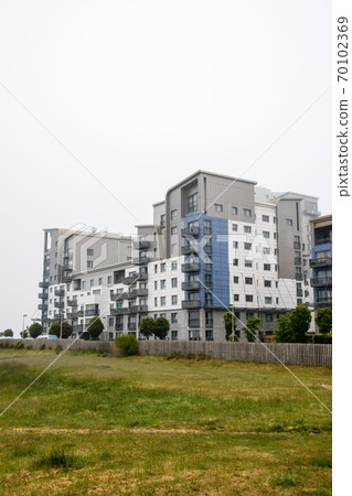 A group of modern condominiums built in the haze of a cloudy sky in the suburbs of Edinburgh 70102369