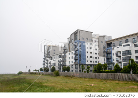 A group of modern condominiums built in the haze of a cloudy sky in the suburbs of Edinburgh A group of modern condominiums built in the haze of a cloudy sky in the suburbs of Edinburgh 70102370