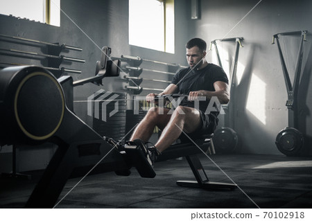 Serious Strong Male Finish Training With Rowing Machine . 70102918