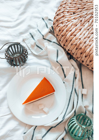 Cheesecake with caramel on a white plate in bed in the room. Vertical photo orientation Cheesecake with caramel on a white plate in bed in the room. Vertical photo orientation 70102953