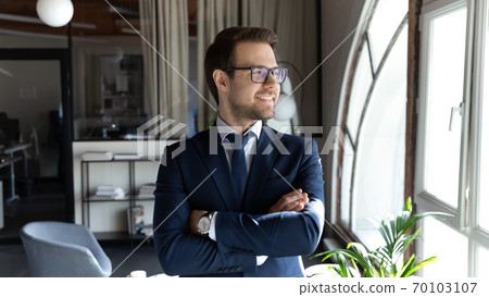Happy smiling pleasant young businessman looking in distance. Happy smiling pleasant young businessman looking in distance. 70103107