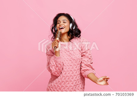 Happy ethnic woman singing in comb Happy ethnic woman singing in comb 70103369
