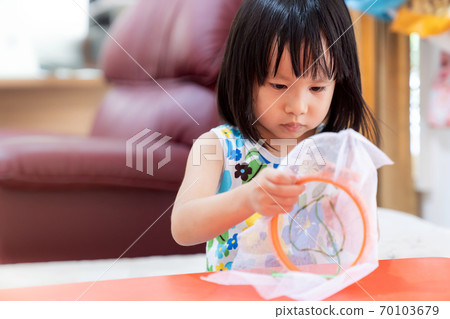 Asian girl home schooling sewing 70103679