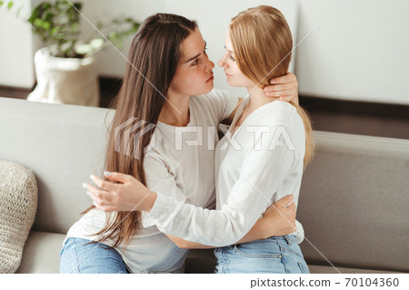 Two young women in love embracing 70104360