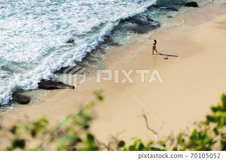 beautiful girl walks along the wild beach 70105052