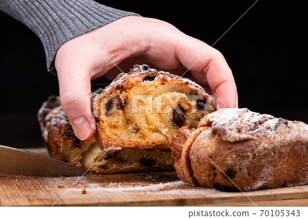 Selective focus. The girl raises a cut piece of homemade raisin pie. Selective focus. The girl raises a cut piece of homemade raisin pie. 70105343